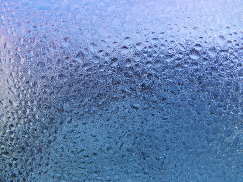 water drops and frost on window glass, close-up natural texture