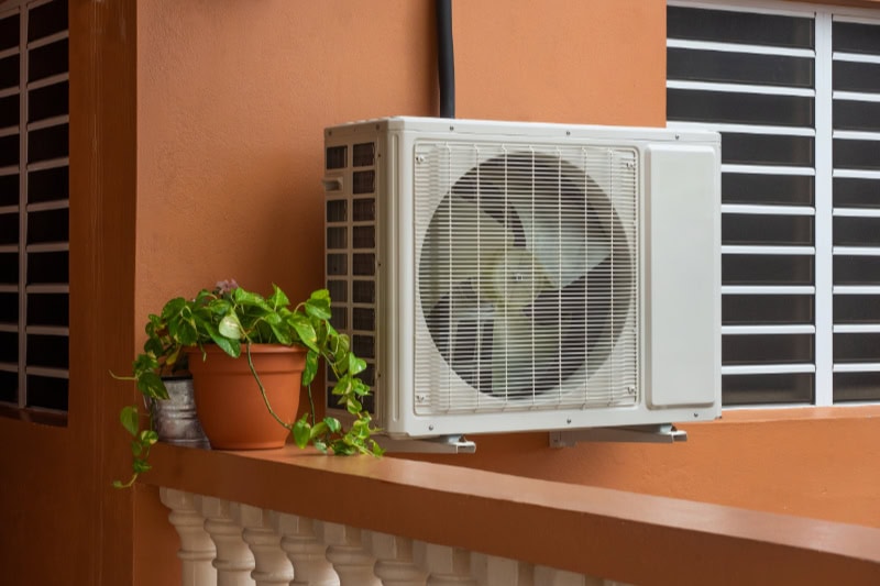 Air Conditioners Versus Heat Pumps. High efficiency modern AC-heater inverter unit, energy save solution-horizontal, outside a house.